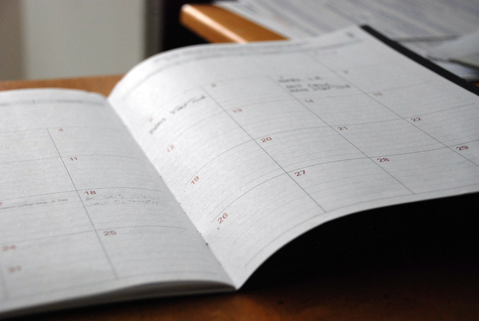 Open monthly planner on a wooden desk representing a compliance budget timeline
