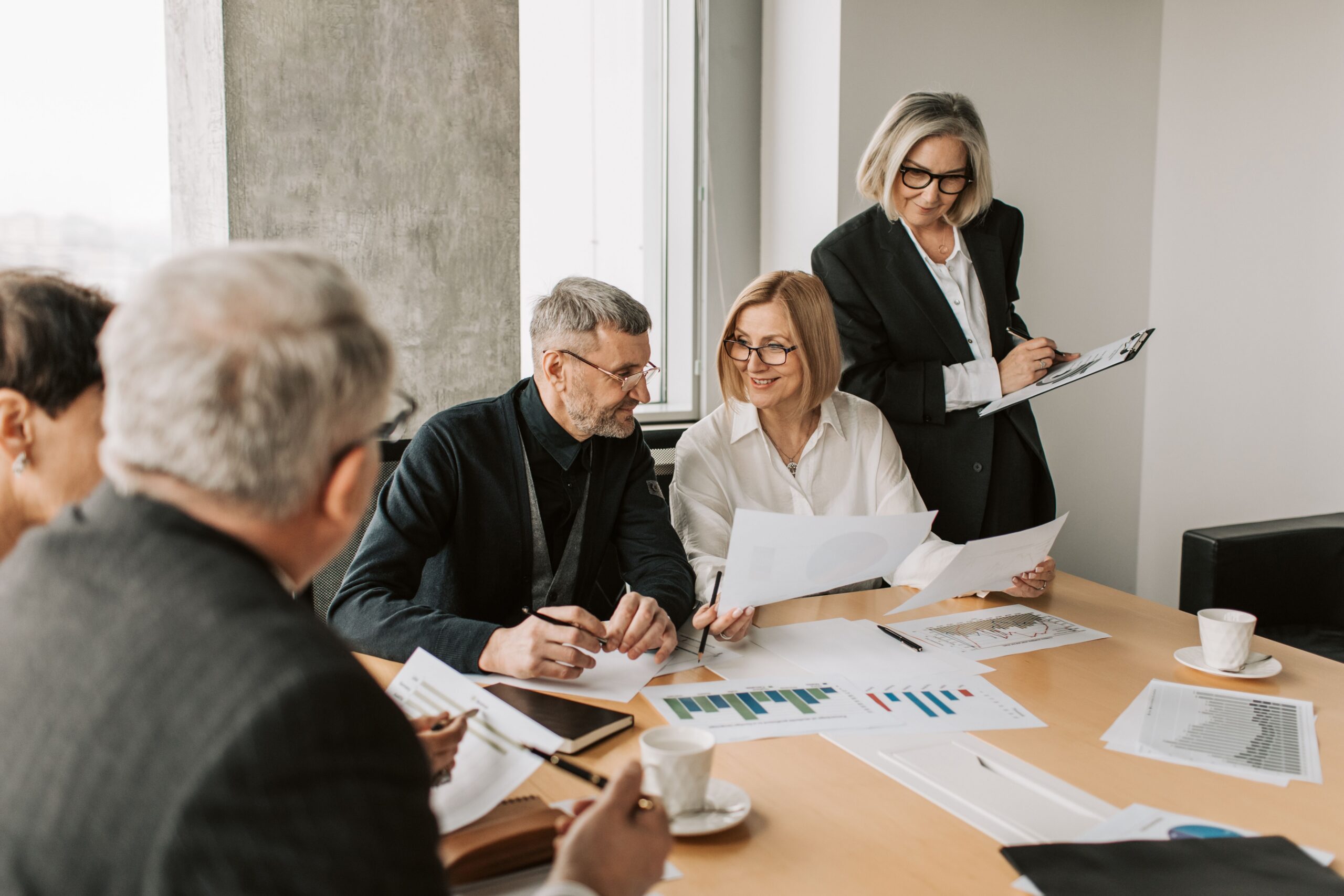 Business professionals examining printed documents together in an office meeting