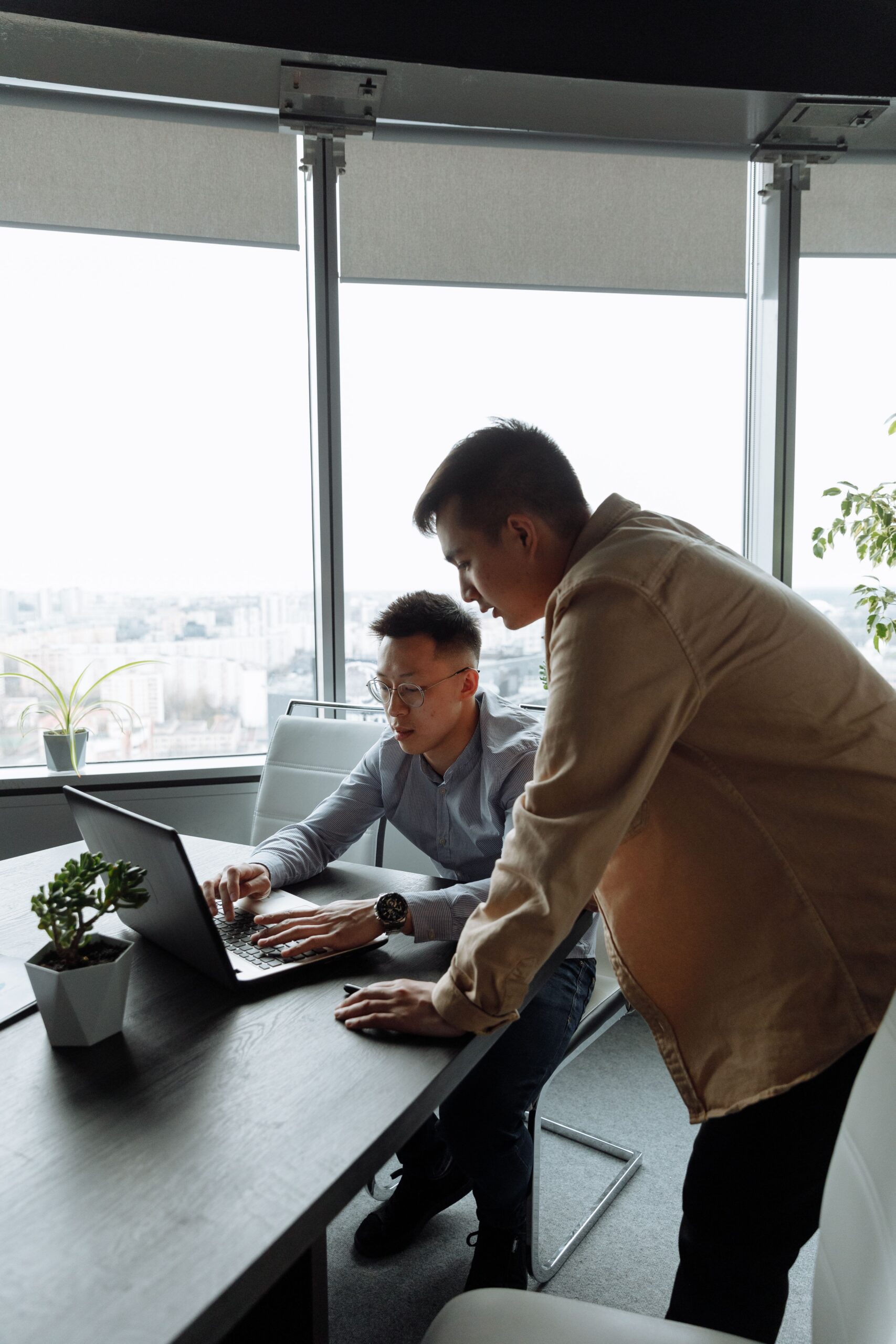Two colleagues reviewing information together on a laptop at a desk